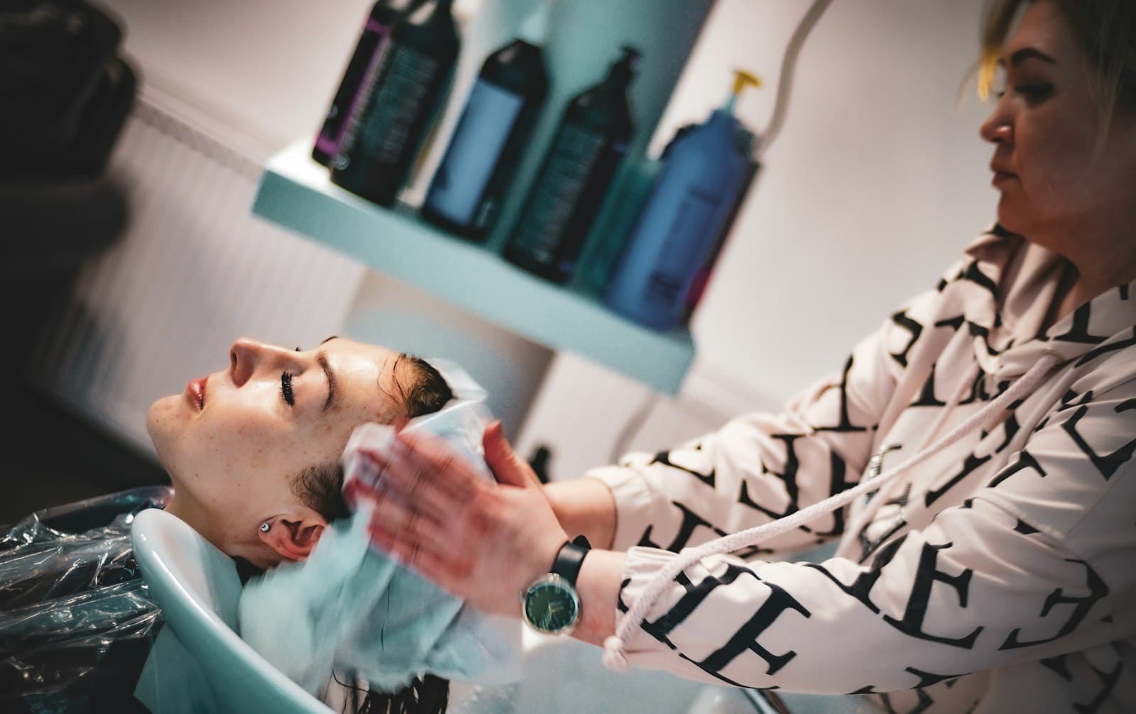 Frisör tvättar håret på en kund vid baljan